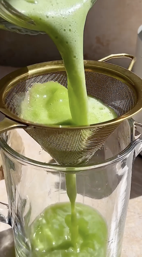 cucumber juice poured through a strainer for a hugo spritz cocktail