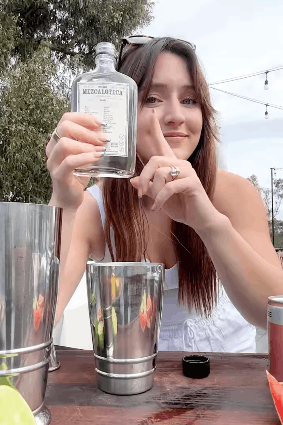 Jules pointing at a bottle of mezcal