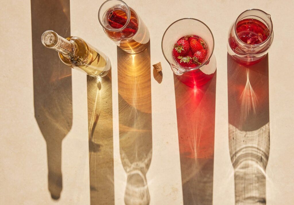four bottle of infused vodka casting long shadows on a table
