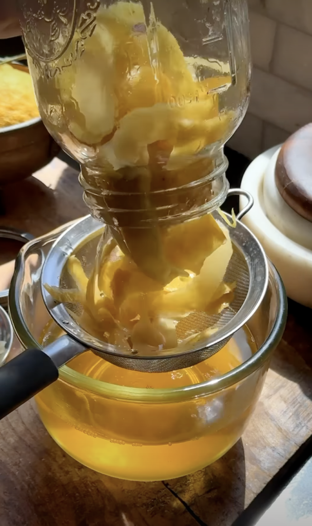 straining lemon peels for limoncello